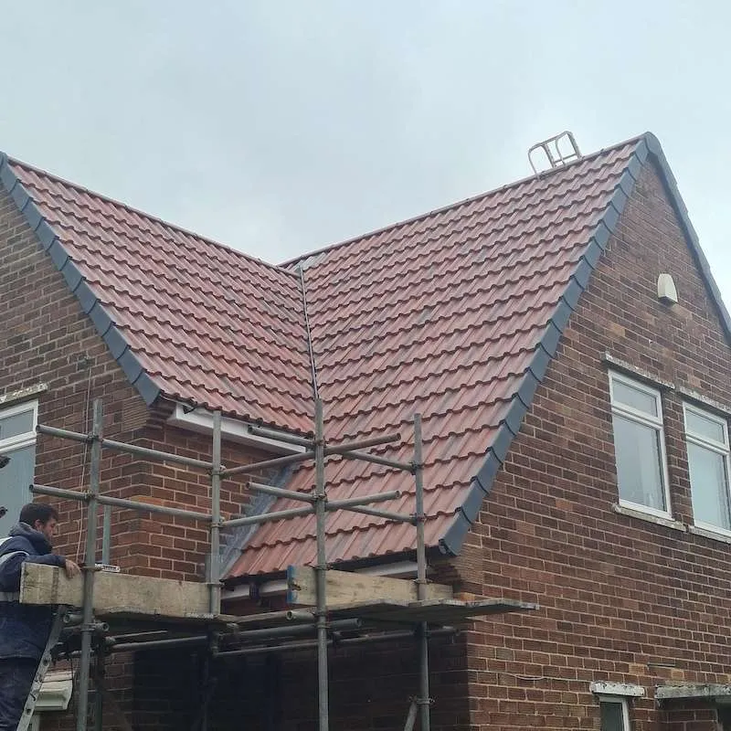 Re-roofing project showing new tiles being installed over prepared battens